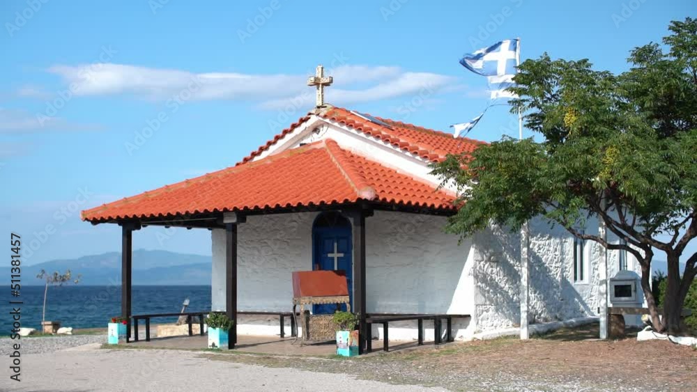 Greek Church on hill, Agean Sea in background. Greek Flag flying Slow Motion Greek Church on hill, Agean Sea in background. Greek Flag flying Slow Motion