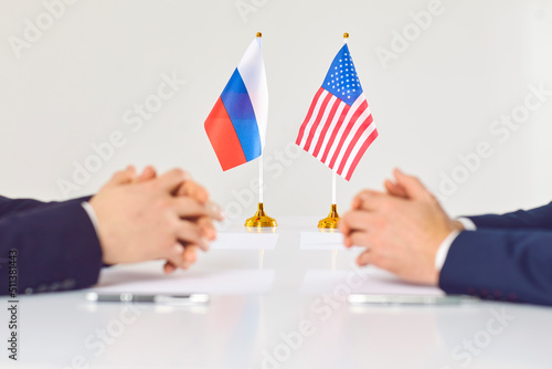 Closeup of Russian and American diplomats sit at table discuss relations. Politicians from USA and Russia negotiate for conflict settlement. International diplomacy. Stop war. photo