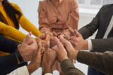 Diverse team of happy business people joining hands as they show thumbs up together. Group of multiracial multiethnic male and female colleagues satisfied with teamwork doing like gestures. Close up