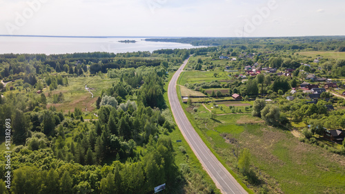 Aerial view of lake and small village. Village near the lake. Aerial view of the village and trees on the shore of lake.