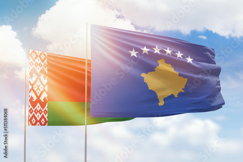 Sunny blue sky and flags of kosovo and belarus