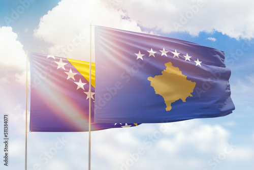 Sunny blue sky and flags of kosovo and bosnia