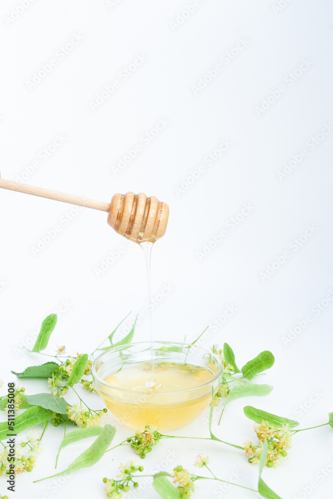 Natural linden honey with linden flowers on a white background Natural linden honey with linden flowers on a white background