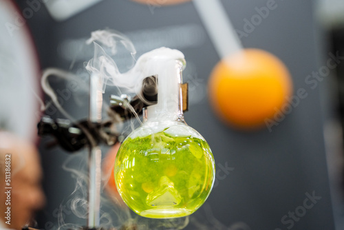 Emission of white smoke from the flask, the reaction of the reagent to the concentrate of chemical resins, laboratory research, heating gasoline in a glass flask. photo