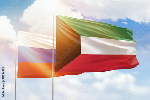 Sunny blue sky and flags of kuwait and russia