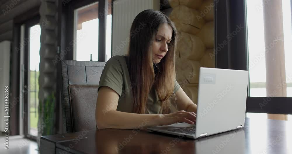 Serious young busy businesswoman working at a laptop at home Serious young busy businesswoman working at a laptop at home