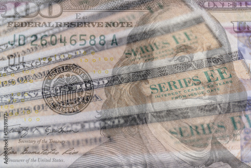 US Savings Bonds with 100 dollar bill overlay. Savings bonds are debt securities issued by the U.S. Department of the Treasury. They are issued in Series EE or Series I. photo