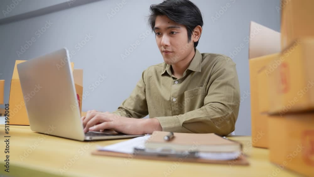 Business concept of 4k Resolution. Young Asian man checking online customer orders in office. Business concept of 4k Resolution. Young Asian man checking online customer orders in office.