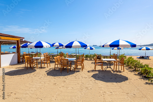 Chairs, lounges and umbrellas along the French Riviera at the sandy beach of Port Grimaud, France, near Saint-Tropez on a summer day along the Mediterranean Sea. © Kirk Fisher