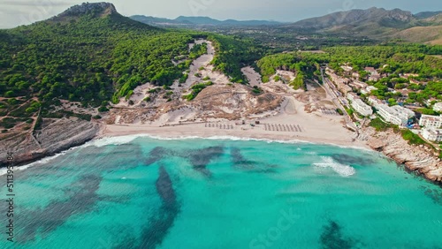 Beautiful Cala Mesquida beach with landscape views on Majorca Island in Spain. Hotels and Resorts with Swimming Pools and Restaurants by a sandy beach with blue water drone view of Balearic Islands. photo