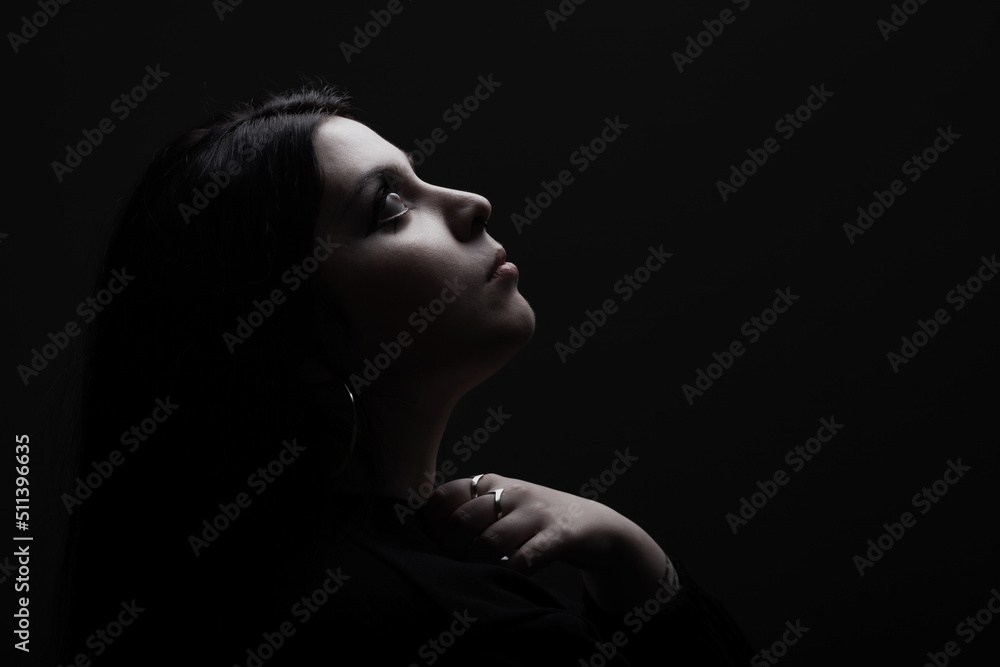 Side lit silhouette portrait of a girl against black background. . Side lit silhouette portrait of a girl against black background. .