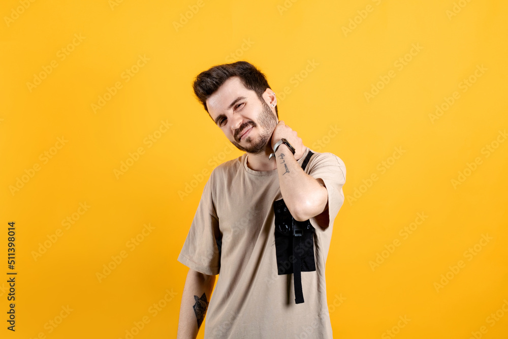 Handsome young man wearing casual clothes posing isolated over yellow background feels physical discomfort unhealthy tired closed his eyes for neck pain. Shoulder ache concept. Handsome young man wearing casual clothes posing isolated over yellow background feels physical discomfort unhealthy tired closed his eyes for neck pain. Shoulder ache concept.
