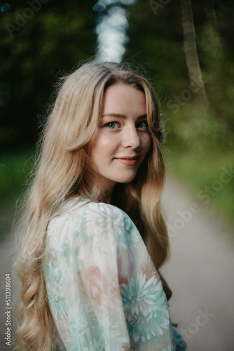 Obraz na płótnie artistic portrait of a tenderly young blonde woman with long hair in a turquoise dress in the forest. w salonie