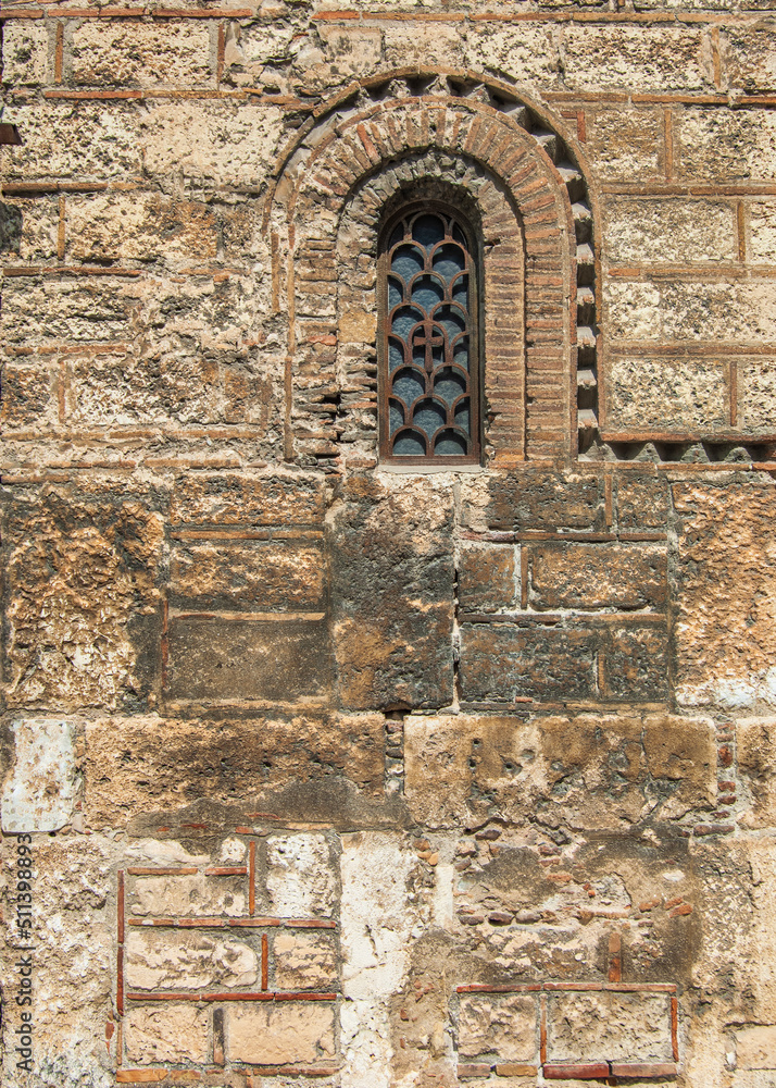 A tiny reinforced window on a medieval church