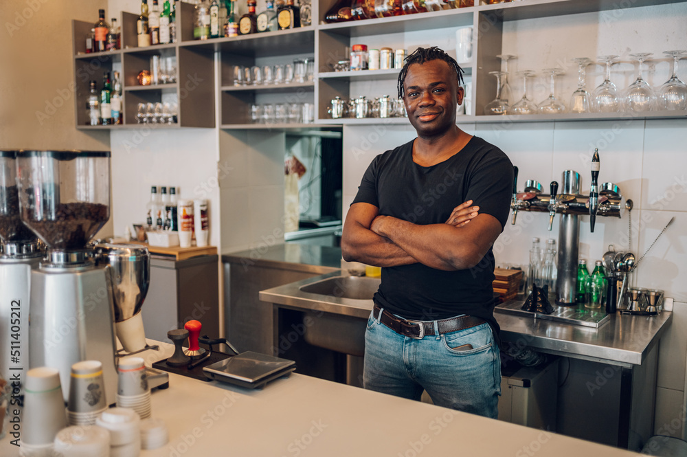 Portrait of an african american male coffee shop owner barista working in a care.