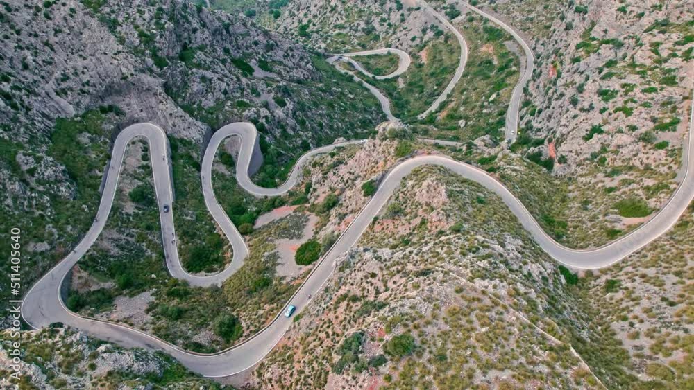 Cars, buses and motorcycles drive on European curved road in Majorca, Spain. Nus de Sa Corbata is a spectacular panoramic snake-like road with curves and rocky landscapes by the Mediterranean. Cars, buses and motorcycles drive on European curved road in Majorca, Spain. Nus de Sa Corbata is a spectacular panoramic snake-like road with curves and rocky landscapes by the Mediterranean.