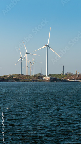 Wind turbines in industrial area by the sea