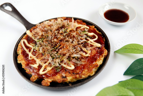 Okonomiyaki in the skillet on the table