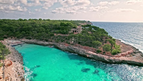 Mediterranean rocky beach with caves in Majorca, Spain with transparent water. Crystal clear sea with turquoise waters by Caló des Borgit beach on Mallorca, Balearic Islands. photo