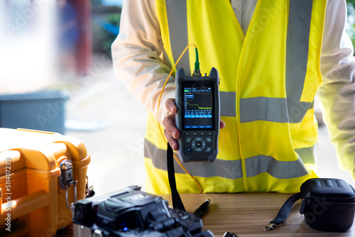 Report from the fiber optic cable quality OTDR meter in the right hand.