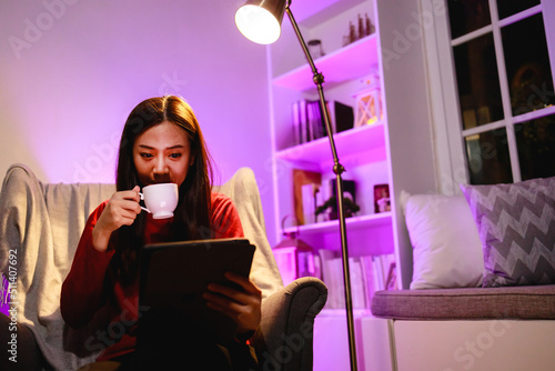 Young woman using a digital tablet at home in night time. technology  internet and people concept