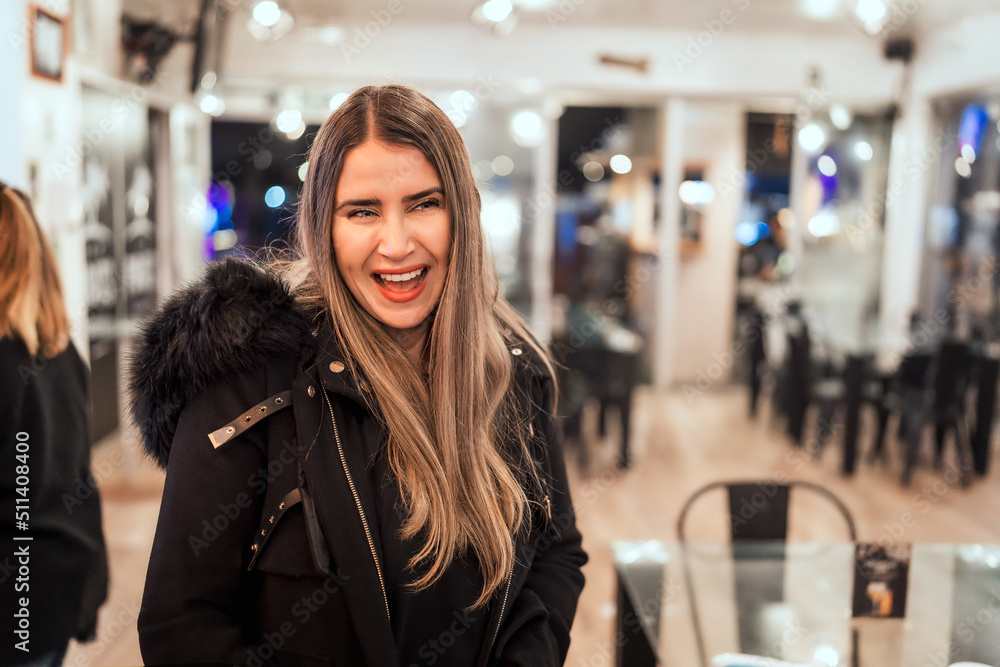Fototapeta premium portrait of smiling caucasian mature woman looking at camera inside cafe pub or restaurant.