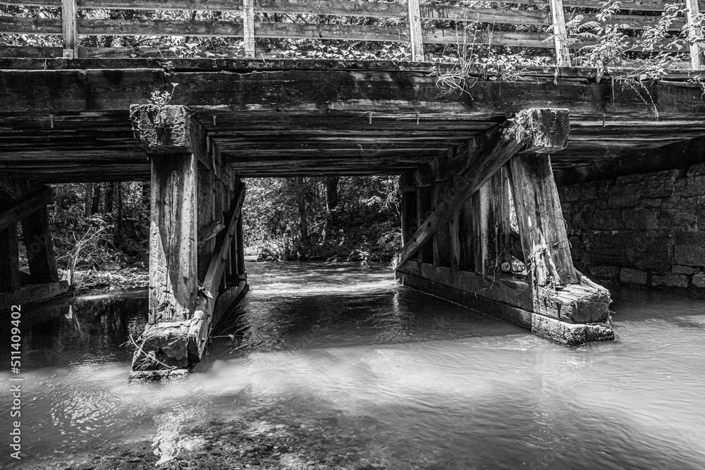 weathered bridge over creek in black and white weathered bridge over creek in black and white
