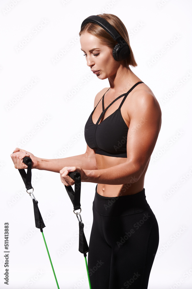 Sportswoman training with resistance bands on white isolated background