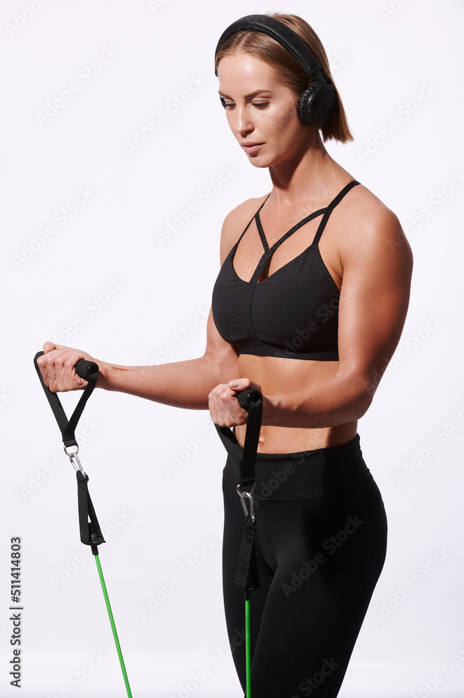 Sportswoman exercising with resistance band over white isolated background