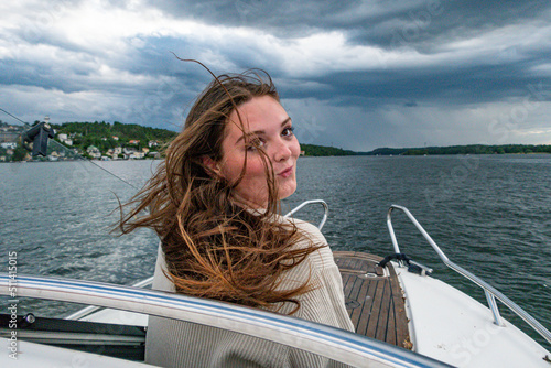 Stockholm, Sweden A young woman enjoying a breeze from a motorboat. © Alexander