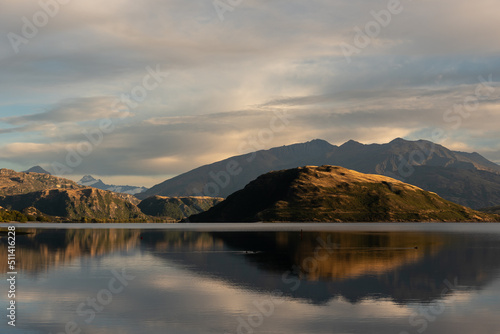 An early morning view from Glendhu Bay on Lake Wanaka with Roy's Peninsula and the mountains of Mount Aspiring National Park reflected in the calm water. Otago, South Island, New Zealand. © Steve