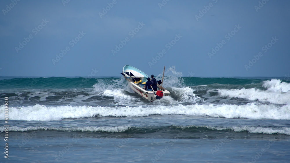 Fishing boat being launched through the surf, from the beach, in Canoa, Ecuador Fishing boat being launched through the surf, from the beach, in Canoa, Ecuador