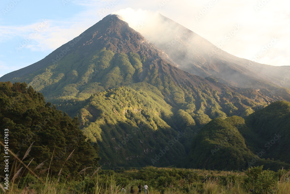 Morning light on mount Merapi Indonesia. Gunung Merapi  or Mount Merapi, is an active stratovolcano located on the border between the province of Central Java and the Special Region of Yogyakarta.