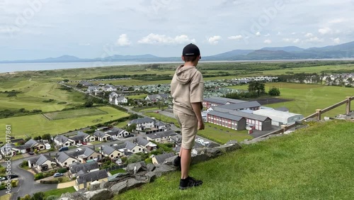 Young boy  looking down onto Harlech from Harlech Castle photo