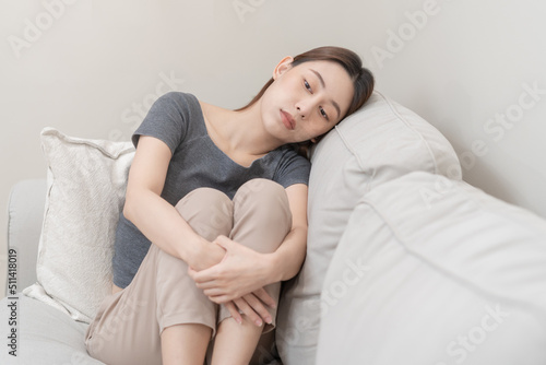 Mental health, depressed sad asian young woman, girl sitting on sofa, couch, expression to face difficulty, failure and exhausted. Thoughtful worried suffering depression feeling lonely, alone at home