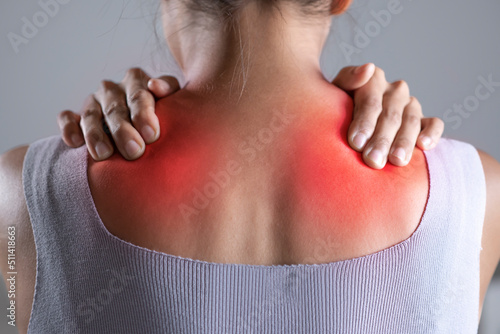Asian woman has shoulder pain. Female holding painful shoulder with another hands. People with body-muscles problem, Healthcare And Medicine. photo