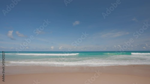 Phuket tropical beach in the high season in Thailand. The waves on the sand beach and the beautiful sky.