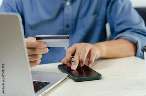person holding a credit card pays bills online through internet banking or online shopping. Business finance marketing concepts. © khunkornStudio
