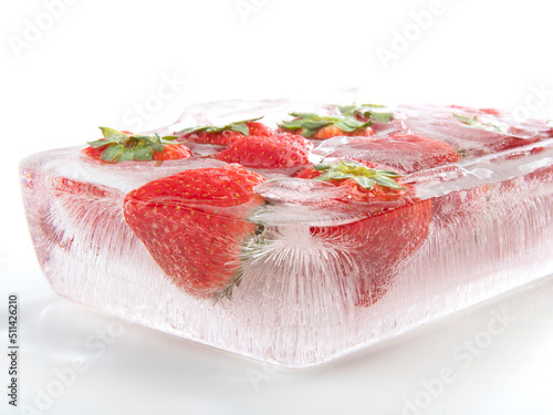 Strawberry frozen inside ice on white background.