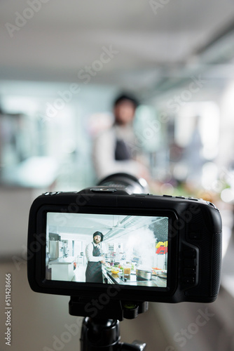 Close up of camera filming gastronomy expert cooking vegetable dish for online culinary school course. Head chef cooking tasty food while vlogging process in restaurant professional kitchen.