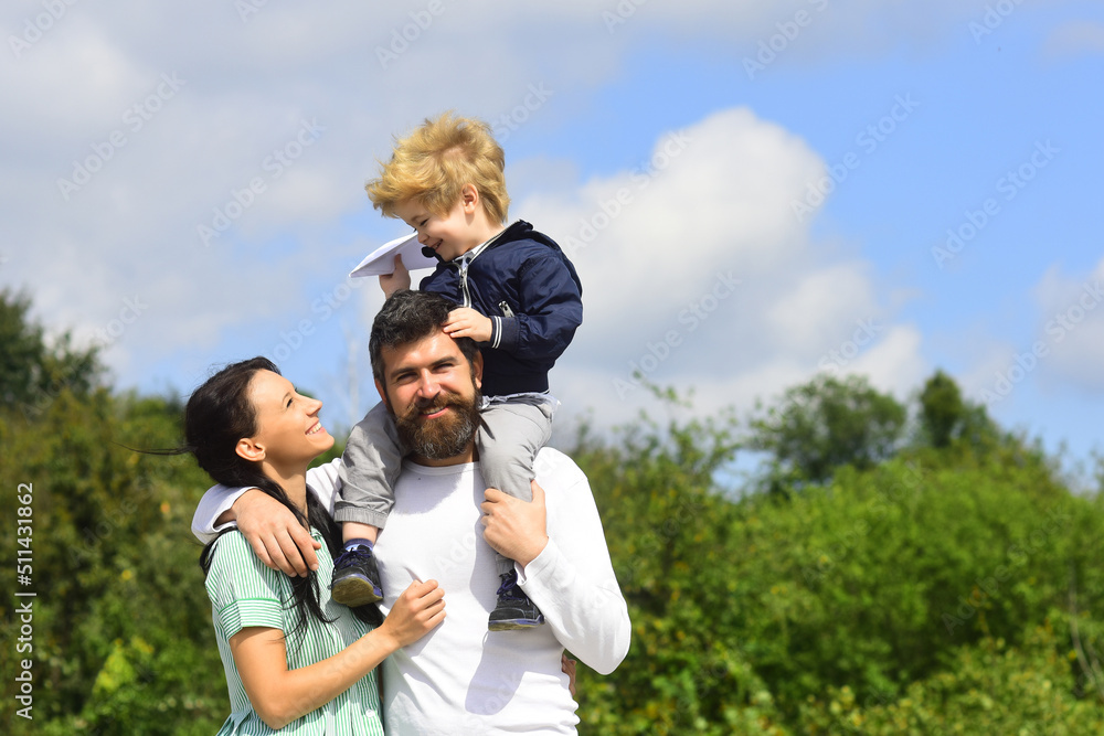 Happy family mother, father and child with toy paper plane. Happy family with children on weekend. Young parents and their child are very happy. Happy family mother, father and child with toy paper plane. Happy family with children on weekend. Young parents and their child are very happy.
