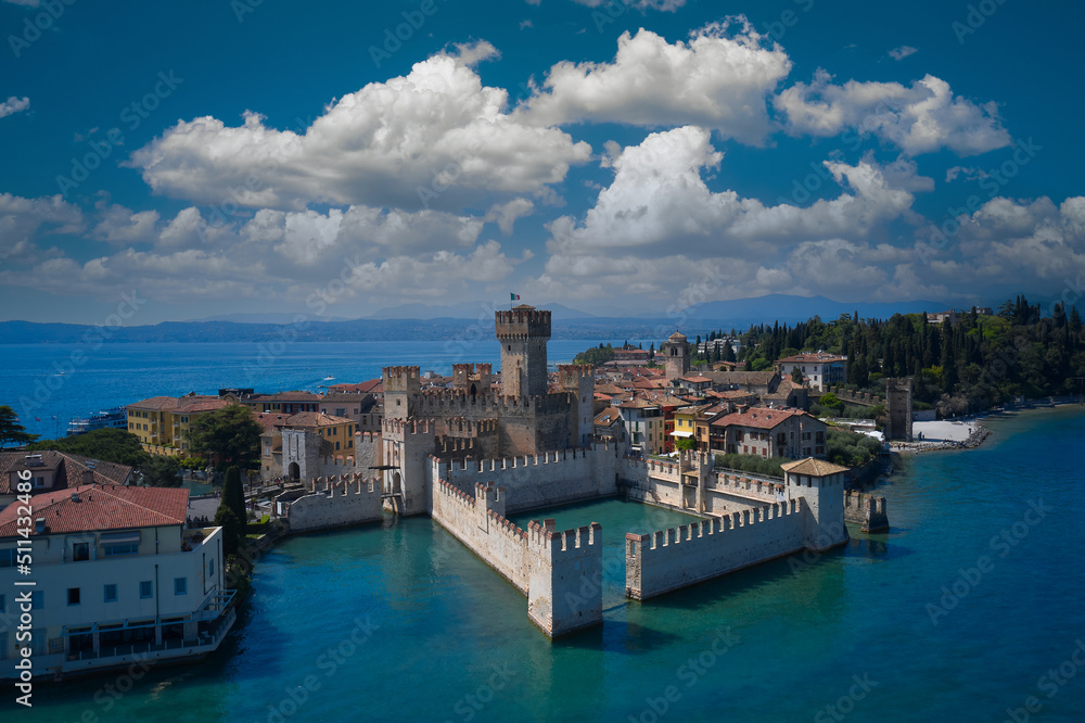 Aerial view of Sirmione, an ancient village on southern Garda Lake. Italian castles Scaligero on the water. Town of Sirmione entrance walls view, Lago di Garda, Lombardy region of Italy drone view.