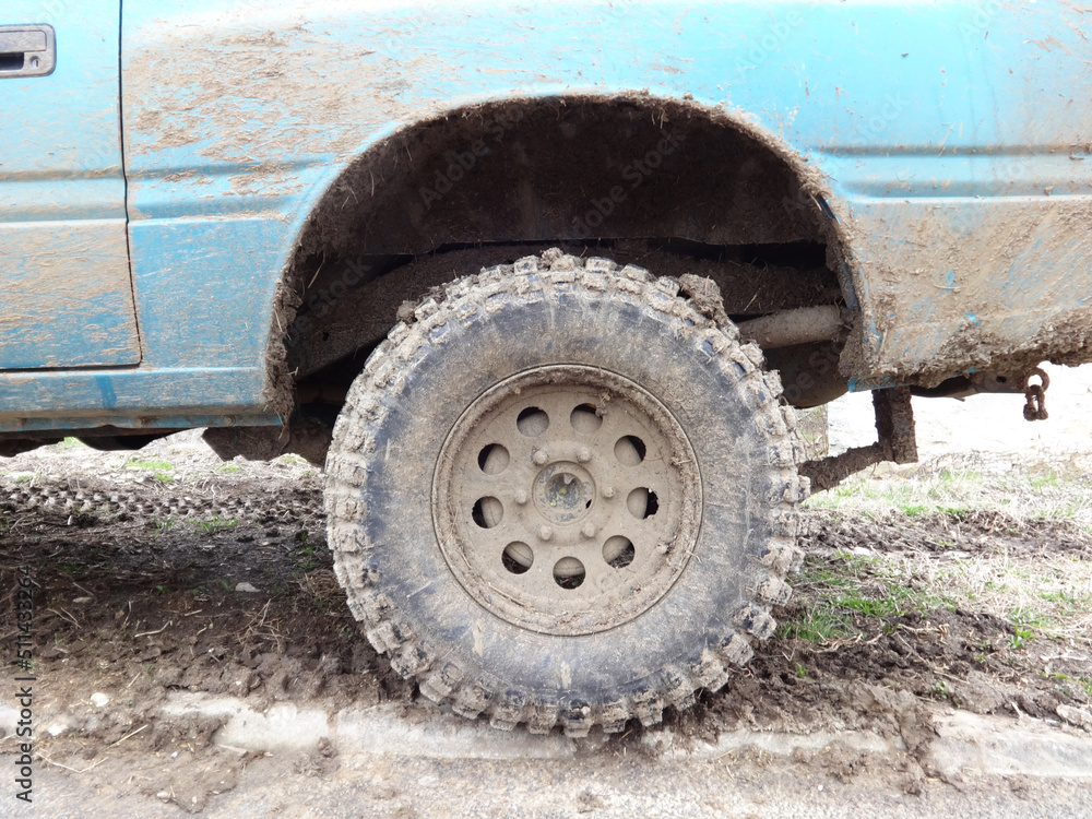 Muddy Wheel of a Blue Jeep