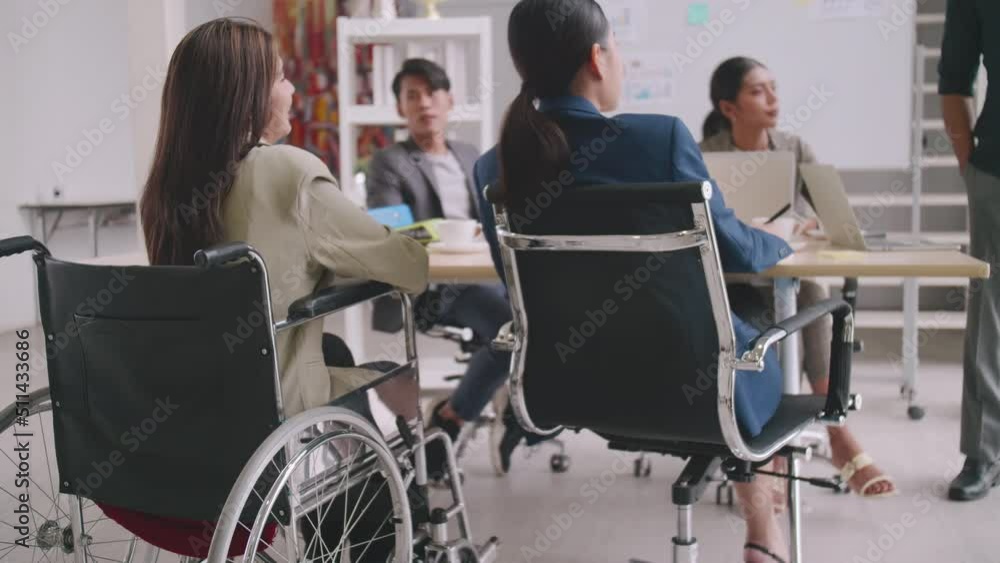 A disabled company employee is able to work happily with colleagues in the office. A group of marketers are having a discussion at the meeting. A disabled company employee is able to work happily with colleagues in the office. A group of marketers are having a discussion at the meeting.