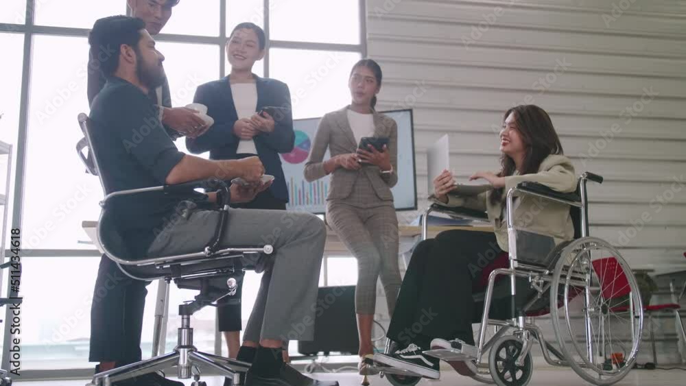 A disabled company employee is able to work happily with colleagues in the office. A disabled company employee is able to work happily with colleagues in the office.