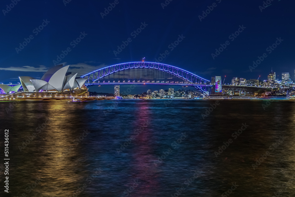 Colourful Light show at night on Sydney Harbour NSW Australia. The bridge illuminated with lasers and neon coloured lights. Sydney laser light show