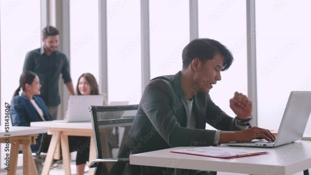A young company employee is feeling tired while sitting at work for a long time. A young company employee is feeling tired while sitting at work for a long time.