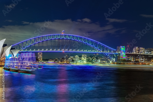 Colourful Light show at night on Sydney Harbour NSW Australia. The bridge illuminated with lasers and neon coloured lights. Sydney laser light show © Elias Bitar