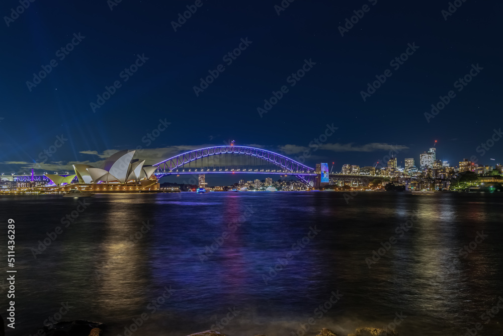 Obraz premium Colourful Light show at night on Sydney Harbour NSW Australia. The bridge illuminated with lasers and neon coloured lights. Sydney laser light show