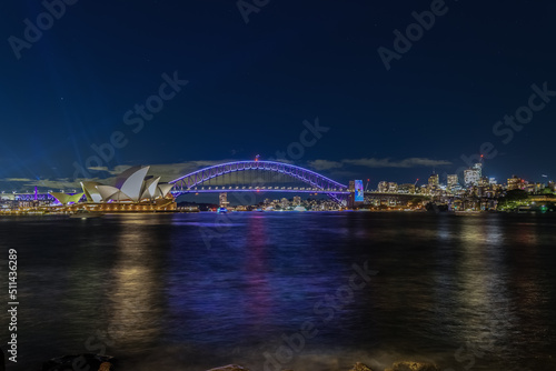 Colourful Light show at night on Sydney Harbour NSW Australia. The bridge illuminated with lasers and neon coloured lights. Sydney laser light show © Elias Bitar